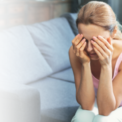 Woman sitting down with her head in her hands.